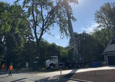 work crew in a neighborhood with a crane